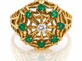 Gros plan sur une bague en or ornée d'émeraudes et de diamants