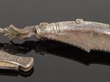 two pieces of silver that are on a black surface