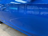 a blue car that is parked on the side of the street