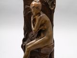 sculpture en bronze représentant une femme assise sur un rocher, la main posée sur le menton