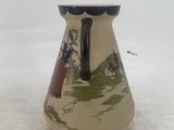 a small vase with a painting on it sitting on a table