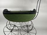 an old fashioned baby carriage with a green seat and black wheels