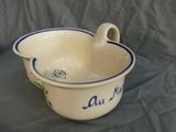 a white bowl with blue trim and a handle