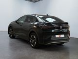 a black car is parked in a large room with a white wall