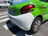 a green and white car that is parked on the side of the road