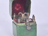 a small green box with a silver object inside of it