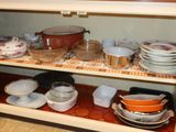 a shelf with dishes and bowls on it in the kitchen