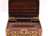a small wooden box with a gold decoration on it