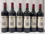 six bouteilles de vin sont alignées sur une table