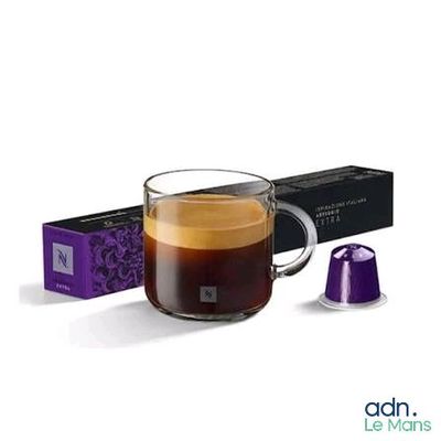 a cup of coffee next to a box of coffee capsules