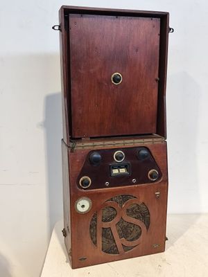 Une radio à l'ancienne est posée sur un meuble en bois