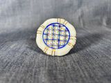 a close up of a white and blue ring on a blue cloth