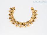 a close up of a gold necklace on a white surface