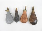 Quatre modèles différents de sacs à main en cuir sont alignés sur une surface blanche