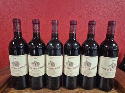 six bouteilles de vin rouge sont alignées sur un tonneau en bois