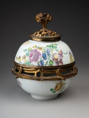 un vase blanc et doré orné de fleurs