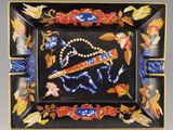 une assiette noire sur laquelle est représenté un cheval et des fleurs