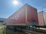 un grand camion-fourgon rouge garé sur le bord de la route