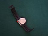 a watch that is laying on a green surface