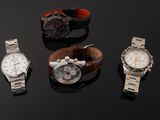 several different watches on a black surface with a black background