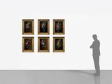 a man standing in front of a wall with paintings on it