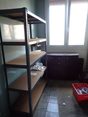 a room with a shelf and a red bin in it