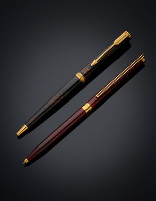 a pair of fountain pens on a black background