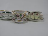 three tea cups and saucers are lined up on a white surface