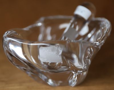 un bol en verre posé sur une table, dans lequel se trouve une brosse à dents