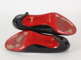 pair of black and red shoes on a white surface