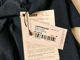 a picture of a black sweater with a price tag on it