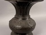 a metal vase that is sitting on a table
