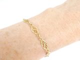 gold plated bracelet with filigree design on a woman ' s arm