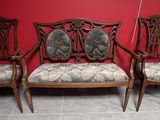 quatre chaises avec des coussins rembourrés à motifs floraux devant un mur rouge
