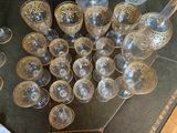 a lot of wine glasses on a table with a bottle
