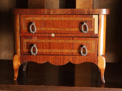 une petite commode en bois posée sur une table