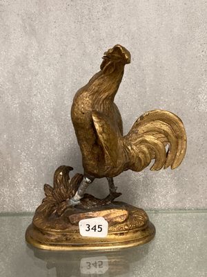 statue d'un coq posée sur une table en verre, avec une étiquette de prix