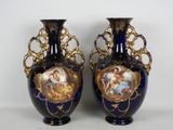une paire de vases bleus ornés de motifs dorés sur fond blanc
