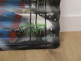 a black suitcase with graffiti on it sitting on a wooden floor