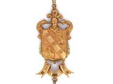 une image représentant un pendentif en or orné d'un blason et d'une perle
