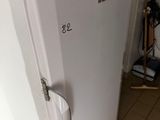 a white refrigerator in the corner of a kitchen