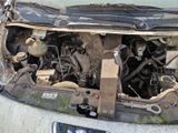 une voiture sale, le capot ouvert et le moteur à l'arrière
