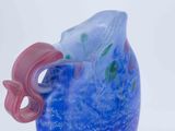 a blue vase with a pink handle on a white surface