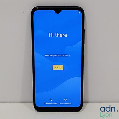 a close up of a cell phone on a table with a blue screen