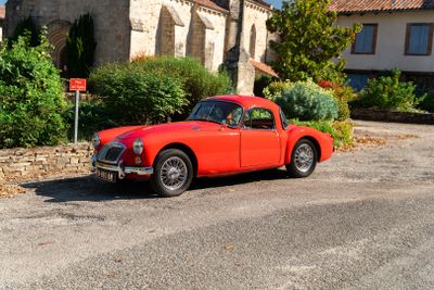 une voiture rouge garée devant un bâtiment