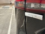 a sticker on the back of a car that is parked in a parking lot