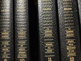 several books are lined up on a shelf in a library