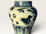 a blue and white vase with a bird on it
