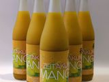 six bouteilles de jus d'orange sont alignées sur une surface blanche