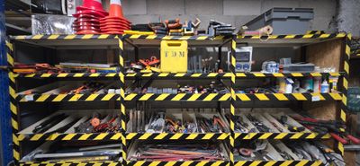 un porte-outils dans un garage, rayé de jaune et de noir
